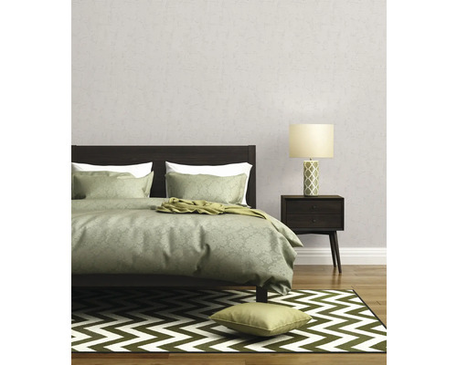 Schlafzimmer mit Bett, Nachttischlampe und gemusterter Tapete