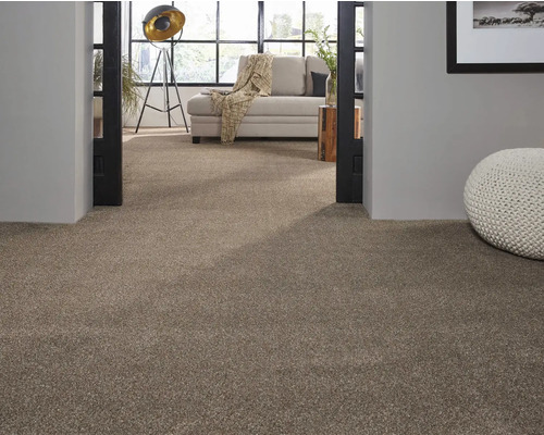 Moquette beige dans un salon avec canapé clair et pouf décoratif