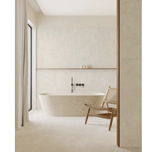 Salle de bain lumineuse avec baignoire îlot, robinetterie, étagère et chaise.