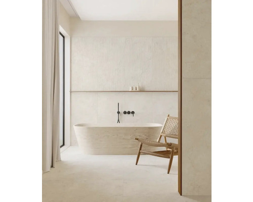 Helles Badezimmer mit freistehender Badewanne, Armatur, Ablage und einem Stuhl.