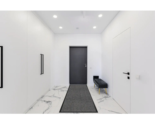 Couloir lumineux avec vestiaire, porte d''entrée, porte intérieure, banc et paillasson sur sol en marbre