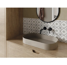 Intérieur de salle de bains avec lavabo, robinet, miroir et carrelage décoratif
