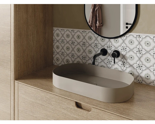Intérieur de salle de bains avec lavabo, robinet, miroir et carrelage décoratif