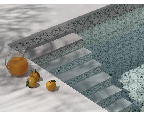 Piscine avec escalier, motif de carreaux et un pichet de jus d''orange