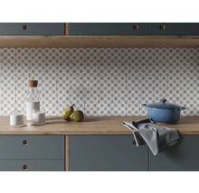 Scène de cuisine avec carrelage, casserole, torchon, carafe, verres et poires sur un plan de travail