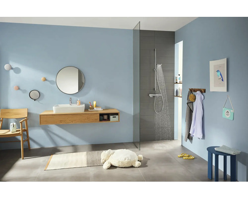 Modernes Badezimmer mit Dusche, Waschtisch, Spiegel und Accessoires.