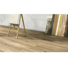 Plancher en bois clair avec chevalet et tableaux