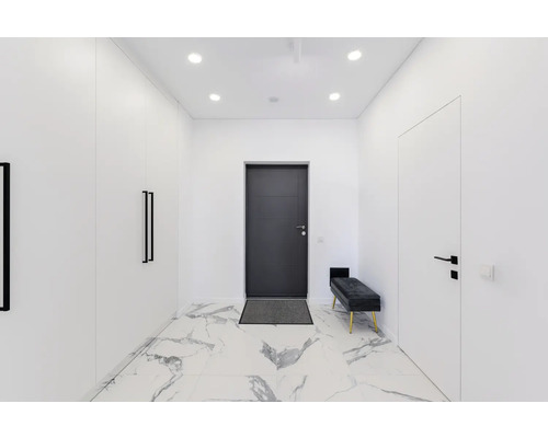 Couloir lumineux avec armoire, porte, banc et sol en marbre