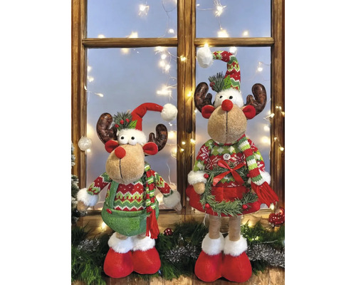 Zwei Rentierfiguren mit weihnachtlicher Kleidung vor einem Fenster