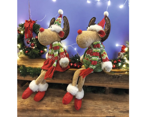 Deux figurines de rennes assises avec des bonnets et des écharpes comme décoration festive