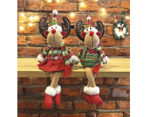Deux figurines de rennes de Noël avec bois, chapeaux et vêtements d''hiver assises sur une étagère.