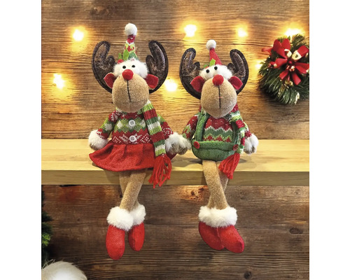 Deux figurines décoratives de rennes avec des vêtements de fête sont assises sur une étagère.