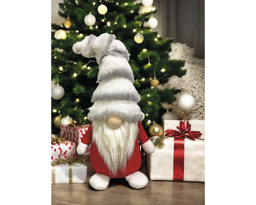 Dekorativer Weihnachtswichtel vor Weihnachtsbaum und Geschenken