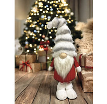 Nain de Noël comme décoration devant le sapin de Noël et les cadeaux