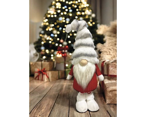 Weihnachtlicher Zwerg als Dekoration vor Weihnachtsbaum und Geschenken