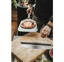 Scène avec pizza sur pelle à pizza, roulette à pizza et planche à découper