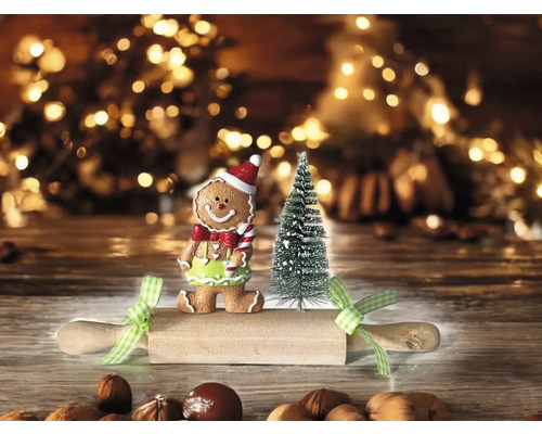 Weihnachtliche Szene mit Lebkuchenmann, Miniaturweihnachtsbaum und Teigrolle