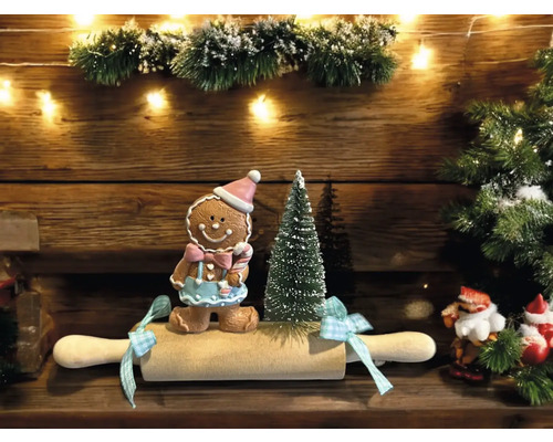 Weihnachtliche Dekoration mit Lebkuchenmann, Miniaturweihnachtsbaum und Nudelholz
