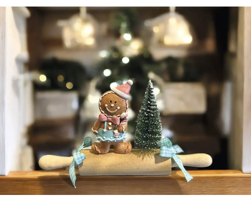Weihnachtliche Dekoration mit Lebkuchenmann, kleinem Weihnachtsbaum und Nudelholz