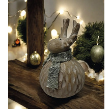 Figurine décorative d''élan avec écharpe sur une table en bois, entourée de décorations de Noël