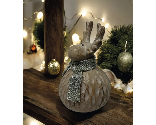 Figurine décorative d''élan avec écharpe sur une table en bois, entourée de décorations de Noël