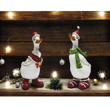 Zwei dekorative Gänsefiguren mit Weihnachtsmützen, Schals und Stiefeln auf einem Regal.