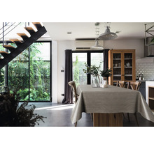 Salle à manger lumineuse avec table, nappe et vue sur le jardin