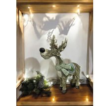 Renne décoratif avec écharpe sur une étagère avec sapin de Noël et lumières