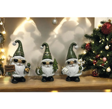 Dekorative Weihnachtsfiguren mit Weihnachtsmotiven vor einem dekorierten Weihnachtsbaum