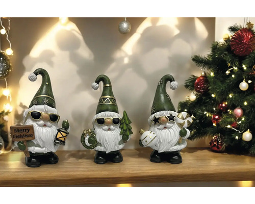 Dekorative Weihnachtsfiguren mit Weihnachtsmotiven vor einem dekorierten Weihnachtsbaum