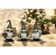 Dekorative Weihnachtszwerge mit Hüten und Sonnenbrillen vor Weihnachtsbaum