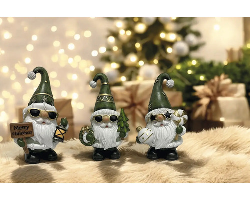 Dekorative Weihnachtszwerge mit Hüten und Sonnenbrillen vor Weihnachtsbaum