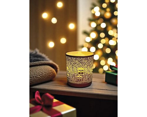 Windlicht mit Häusermuster vor Weihnachtsdekoration