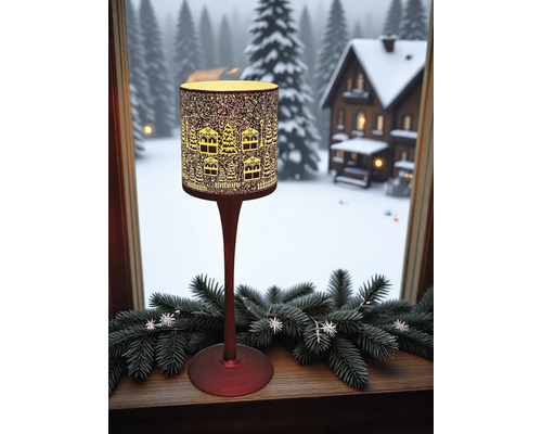 Dekorative Stehlampe mit Winterdorf-Motiv am Fenster