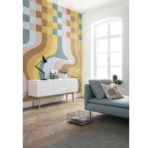 Salon moderne avec papier peint à motifs, buffet blanc et canapé bleu clair.