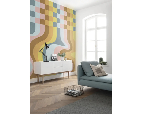 Salon moderne avec papier peint à motifs, buffet blanc et canapé bleu clair.