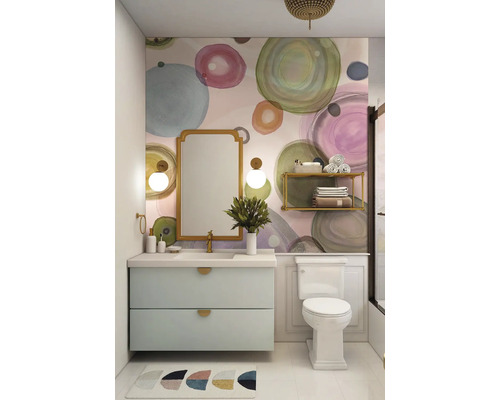 Salle de bains lumineuse avec meuble sous-lavabo, miroir et toilettes devant un mur à motif circulaire