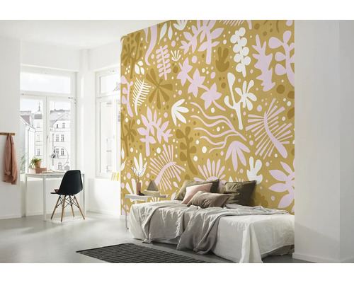 Chambre avec papier peint à motifs, lit, bureau et chaise.