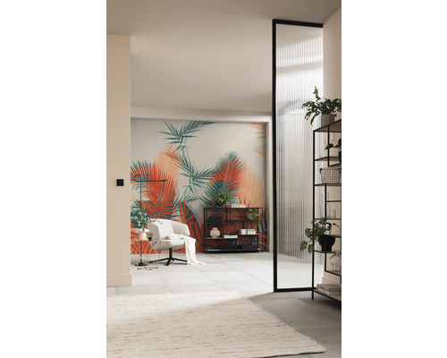 Wohnzimmer mit tropischer Fototapete, Sessel, Regalen und geriffelter Glastür