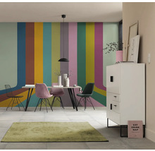 Salle à manger avec table, chaises, buffet et tapis devant un mur à rayures