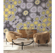 Salon avec deux fauteuils, table basse, buffet et papier peint à motif abstrait