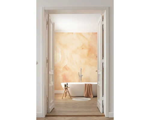 Salle de bains avec baignoire et décor mural abstrait à travers une porte ouverte