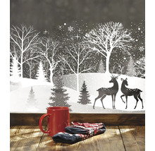 Winterliche Fensterdekoration mit Tasse und Handschuhen im Vordergrund