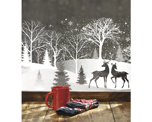 Winterliche Fensterdekoration mit Tasse und Handschuhen im Vordergrund