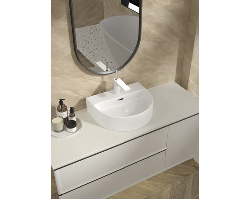 Badezimmerwaschtisch mit Spiegel und Armatur in einem hellen Badezimmer