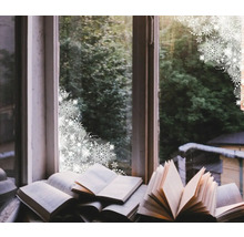 Dekoratives Arrangement mit geöffneten Büchern auf einer Fensterbank vor einem Fenster mit Blick auf Bäume und Schneeflockenmuster