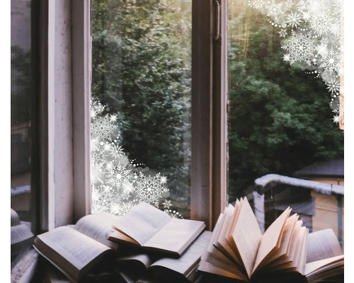 Dekoratives Arrangement mit geöffneten Büchern auf einer Fensterbank vor einem Fenster mit Blick auf Bäume und Schneeflockenmuster