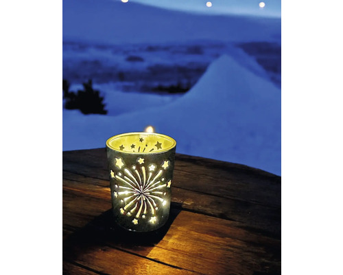 Windlicht mit Sternen- und Feuerwerksmuster auf einem Holztisch