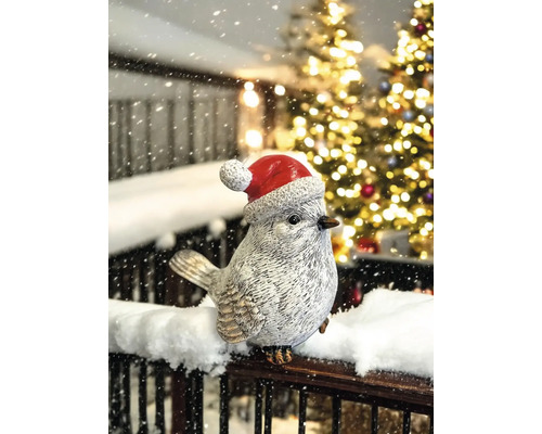 Dekorative Vogelfigur mit Weihnachtsmütze im winterlichen Umfeld