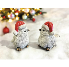 Deux oiseaux décoratifs avec des bonnets de Noël comme décorations de Noël